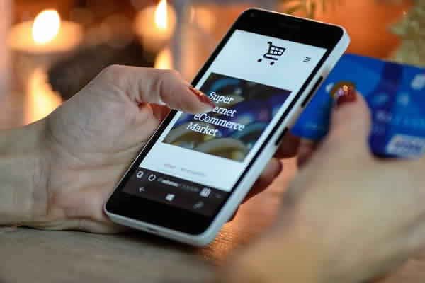 Vista de una mano de mujer con una tienda en su smartphone. Actualizamos tu sitio o tienda.