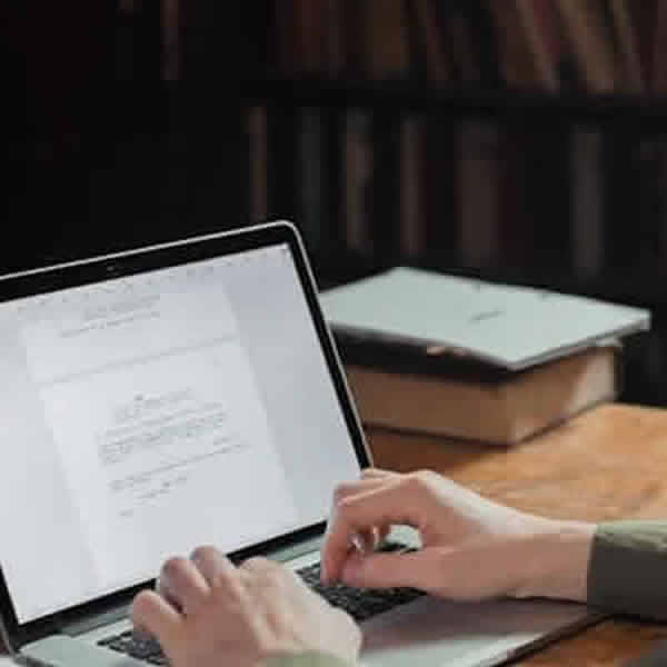 Foto: Persona escribiendo en una notebook con procesador de texto. Creación de contenidos